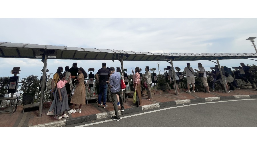 山頂擠滿俯瞰城市全景或檳城大橋的人們